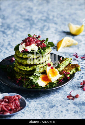 Das gesunde Essen, glutin kostenlose Green pea Pfannkuchen stack. Mit Ziegenkäse, Ei, watercrese und Minze Grüns und eine Seite von leicht reduzierter Balsamico rot Oni Stockfoto