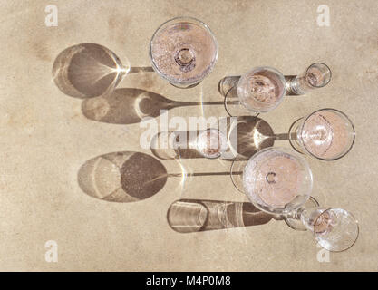 Vielzahl von schönen Weingläser mit Rose Champagne mit dramatischen Schatten auf eine konkrete Oberfläche gefüllt. Stockfoto