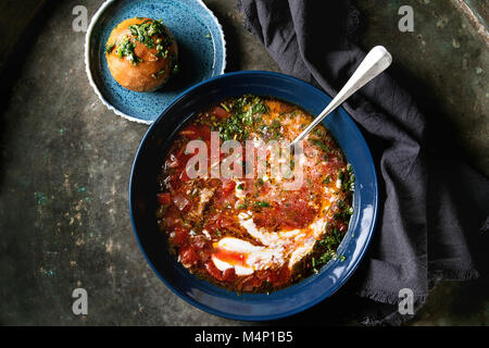 Platte der traditionellen Rote-Bete-Suppe Borschtsch mit saurer Sahne, Löffel und frischem Koriander serviert mit Knoblauch Brötchen pampushka mit schwarzem Textil napki Stockfoto