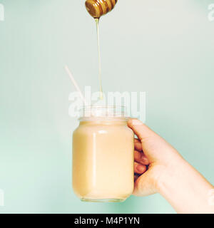 Womans Hand smoothie Schütteln gegen helle Wand. Trinken gesunde Smoothie Konzept Stockfoto