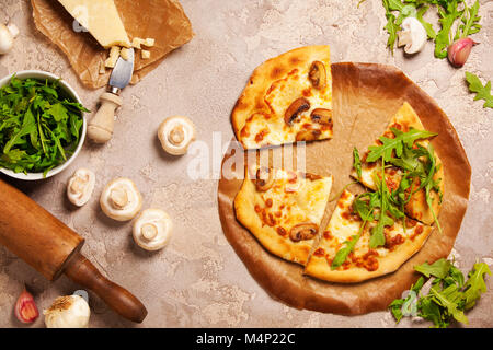 Veggie Pizza mit Zutaten aus alten Stein Hintergrund. Pizza mit Käse, Champignons und ruccola. Rustikale italienische Pizza Stockfoto