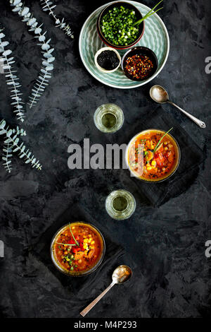 Schalen von Sesam Linsensuppe garniert mit gebratenen Paprika und Schnittlauch. Auf einem Schwarz/Dunkelgrau Hintergrund fotografiert. Stockfoto