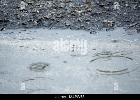 Regen auf Asphalt oder asphaltstraße Wellen erzeugen, verwischt, hohen Kontrast und selektiven Fokus Bild. Stockfoto