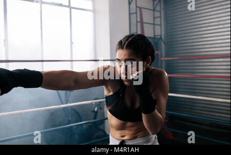 Nahaufnahme eines weiblichen Boxer Ausbildung in einem Boxring. Boxer üben ihr bewegt sich mit Boxen Studio. Stockfoto