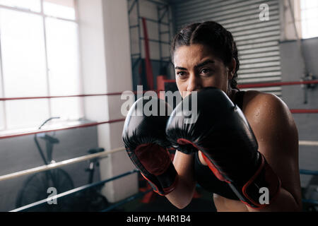 Boxer üben ihr Schläge an einem Boxen Studio. Nahaufnahme eines weiblichen Boxer tun Schattenboxen in einem Boxring. Stockfoto