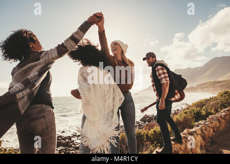 Freunde auf Urlaub lächeln und genießen im Freien. Gruppe von Menschen und Frauen, die eine Böschung am Straßenrand. Stockfoto