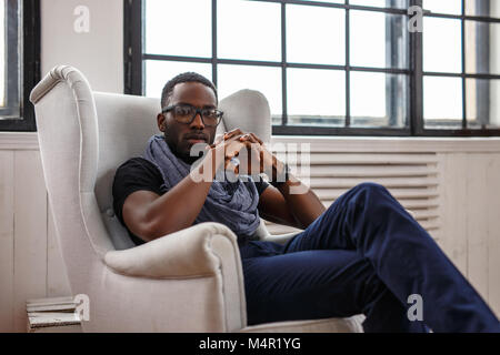 Ein schwarzer Mann in einem weißen Stuhl. Studio shot Stockfoto