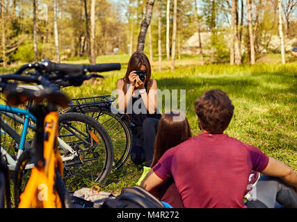 Eine Frau, die Bilder von sportlichen Paar nach der Fahrt mit dem Fahrrad in den Wald. Stockfoto