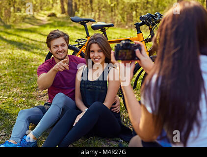 Eine Frau, die Bilder von sportlichen Paar nach der Fahrt mit dem Fahrrad in den Wald. Stockfoto