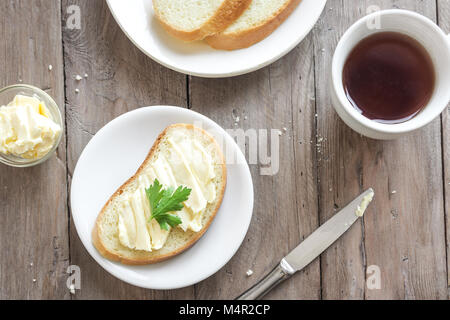 Butter und Brot für das Frühstück, bei einer Tasse Kaffee über rustikal Hintergrund mit kopieren. Morgen Frühstück mit Kaffee, Butter und Toast. Stockfoto