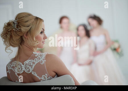 Braut Hochzeit Salon. Vier schöne Mädchen befinden sich in den Armen. Close-up Spitze Röcke Stockfoto