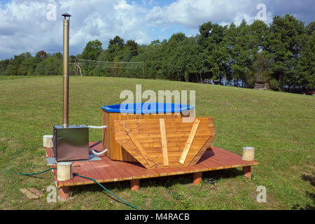 Land Sauna auf einer Waldlichtung im japanischen Stil - grosses Holzfass und Stahl Ofen für Heizung Wasser. Sonnigen Sommer August Tag der ländlichen Landschaft Stockfoto