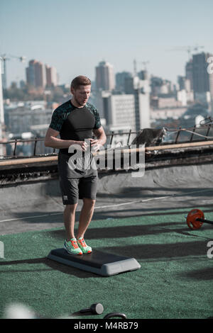 Jungen athletischen Mann Bereit für Training auf dem Dach. Stockfoto