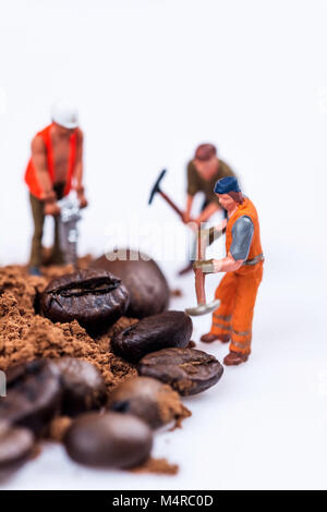 Miniatur Figuren arbeiten auf Kaffee Makrofotografie auf weißem Hintergrund Stockfoto