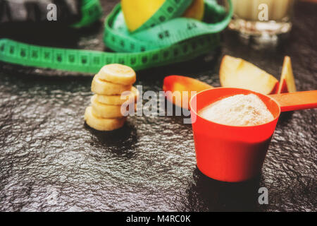 Protein Pulver in Schaufel und Früchte auf steinernen Tisch Stockfoto