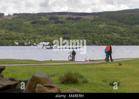 Die | National Trust Steam Yacht Gondola parow bis Coniston Water während Wanderer der Weg entlang der Bank zu Fuß Stockfoto