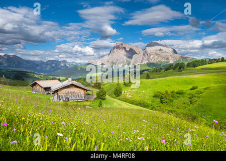 Wunderschöne Aussicht auf idyllischen alpine Berglandschaft mit traditionellen alten Berghütten und frischen grünen Wiesen an einem sonnigen Tag mit blauen Himmel im Sommer Stockfoto