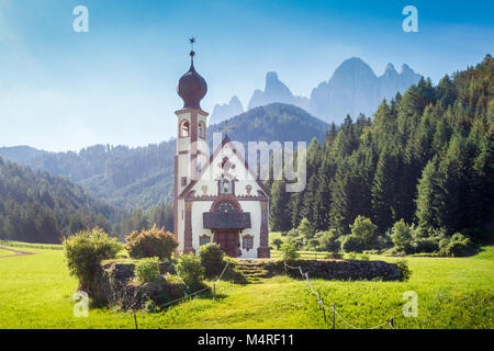 Wunderschöne Aussicht auf idyllischen Berglandschaft in den Dolomiten mit barocken Kirche des Hl. Johann von Nepomuk und der berühmten Geislerspitzen im Hintergrund Stockfoto