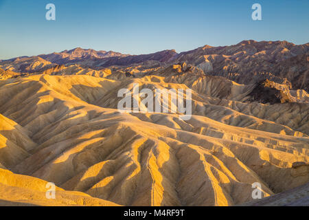 Malerischer Blick auf erstaunliche Sandstein Felsformationen an der berühmten Zabriskie Point Aussichtspunkt im goldenen Abendlicht bei Sonnenuntergang, Death Valley National Park, USA Stockfoto