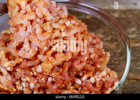 Fleischwolf und einen Haufen gehacktes Fleisch preparated von Fleisch. Kochen Hackfleisch Schleifer. Auf einer hölzernen Tisch. Stockfoto