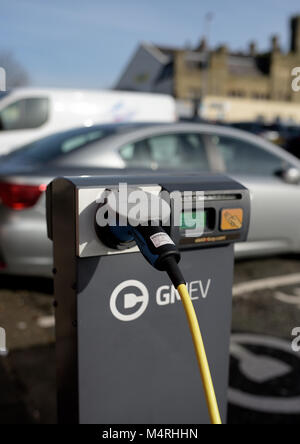 Ladestation für Elektrofahrzeuge von Gmev, Ladestation für Elektroautos vor verschwommenen Autos mit weicher Fokussierung auf dem Parkplatz von Bbury council in lancashire uk Stockfoto