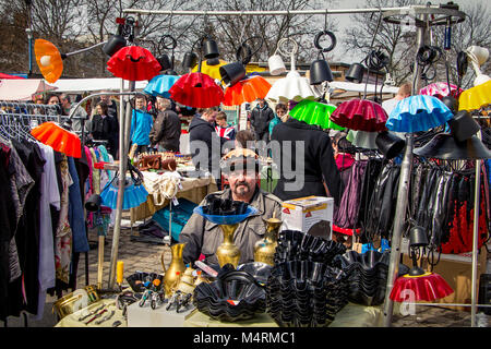 Lustiger Ladenbesitzer unter seinen bunten Lampenschirmen am Mauerpark sonntag Flohmarkt an einem frühen Frühlingstag in Berlin, Deutschland - Europa. Stockfoto