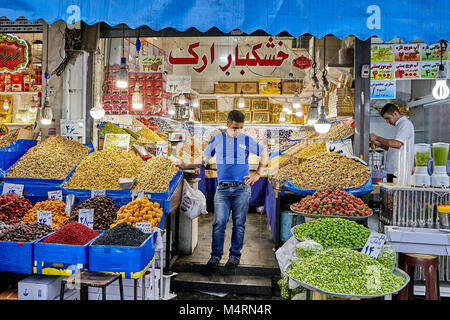 Teheran, Iran - 29. April 2017: Lebensmittelhändler steht in der Mitte seines Store mit getrockneten und frischen Früchten. Stockfoto