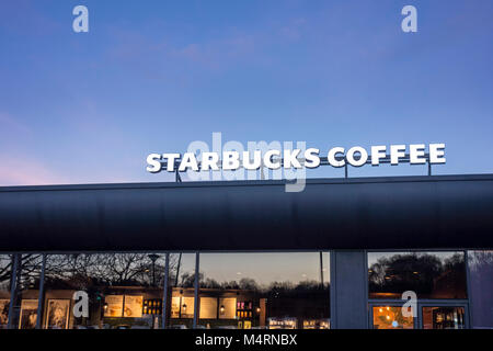 Beleuchtete Starbucks Kaffee Zeichen außerhalb der Shop im Abend, Großbritannien Stockfoto