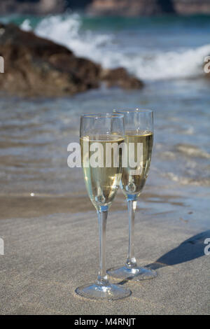 Zwei Gläser kalt weiß Champagner oder Cava Sekt serviert auf dem weißen Sandstrand tropischen Strand, Luxus Resort mit Meerblick, romantischen Urlaub Stockfoto