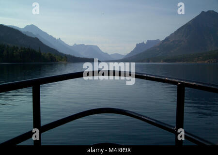 Die Aussicht vom Bug des M.V. International, das Boot, das die Besucher von Waterton Lakes National Park in Alberta, Kanada zu Ziege frequentieren Ranger Station im Glacier National Park, United States. Auf der linken Seite, Silhouette, ist der Frieden Park höchsten Berg. Mt. Cleveland steht an, Füße oder, Meter, und die North Face (hier im Bild) Boote der höchsten vertikalen Aufstieg in die Rocky Mountains.. Auf dem Weg nach Ziege frequentieren. Stockfoto