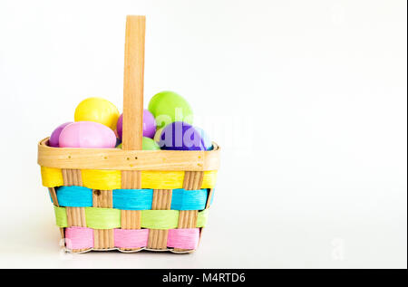 Bunte wicker Ostern Korb mit Kunststoff Ostereier gefüllt isoliert auf weißem Stockfoto