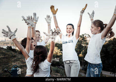 Glückliche freudige Team heben ihre Hände Stockfoto