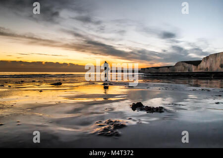 Birling Gap, East Sussex, UK. 17. Februar 2018.. Sonnenuntergang hinter Wolken schafft spektakulären Farben und Reflexionen über den nassen Sand & Pools nach dem anderen herrlichen Frühling wie Tag an der Südküste von England. David Burr/Alamy leben Nachrichten Stockfoto