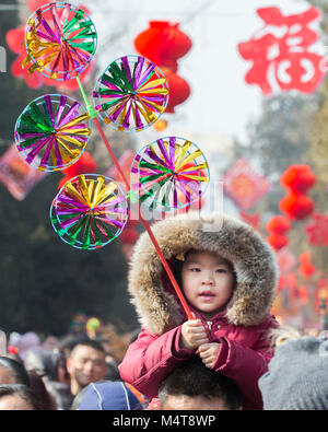 Peking, China. 18 Feb, 2018. Ein Kind mit einem Windrad visits einen Tempel Messe an Ditan Park in Peking, der Hauptstadt von China, Februar 18, 2018. Eine Vielzahl der Tempel Messen wurden im ganzen Land während der Spring Festival Urlaub statt. Credit: Su Yang/Xinhua/Alamy leben Nachrichten Stockfoto