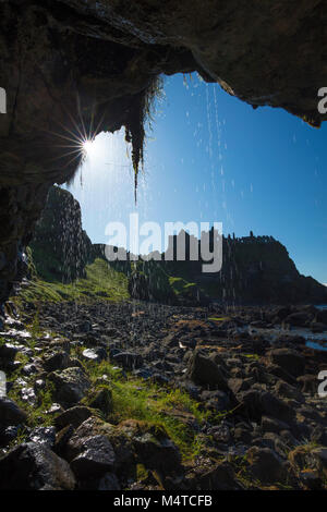 Silhouette von Dunluce Castle von innen eine Wasserhöhle, Causeway Coast, County Antrim, Nordirland. Stockfoto