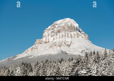 Crowsnest Pass, Alberta, Kanada. Crowsnest Berg im Schnee im Winter gegen den blauen Himmel. Stockfoto