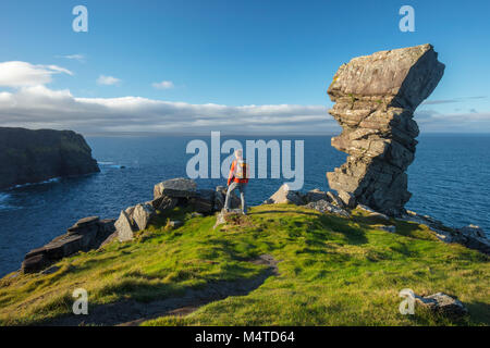 Wanderer und Felsformation an der Hag Kopf, die Klippen von Moher an der Küste zu Fuß, County Clare, Irland. Stockfoto