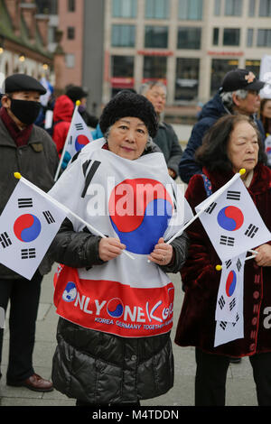 Frankfurt am Main, Deutschland. 17 Feb, 2018. Eine ältere Frau trägt ein Cape mit der Koreanischen Flagge und hält zwei koreanische Fahnen. Südkoreaner leben in Deutschland protestierten in Frankfurt zur Unterstützung des ehemaligen Präsidenten Park Geun-hye, die für ihre Freilassung und für die Amtsenthebung ihres Nachfolgers Moon Jae-in. Quelle: Michael Debets/Pacific Press/Alamy leben Nachrichten Stockfoto