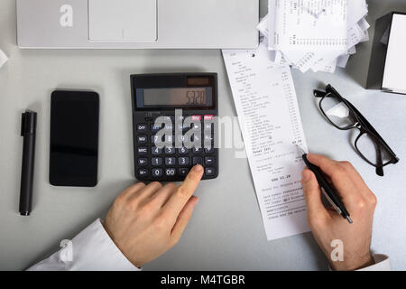 Ansicht der Kaufmann Berechnung Rechnung mit Taschenrechner auf Büro Schreibtisch Stockfoto