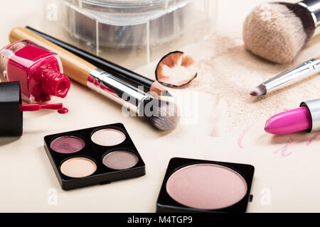 Verschiedene Make-up-Produkte mit Make-up-Pinsel auf beigen Hintergrund Stockfoto