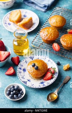 Muffins, Kuchen mit frischen Beeren und Honig auf Kühlung Rack. Stockfoto