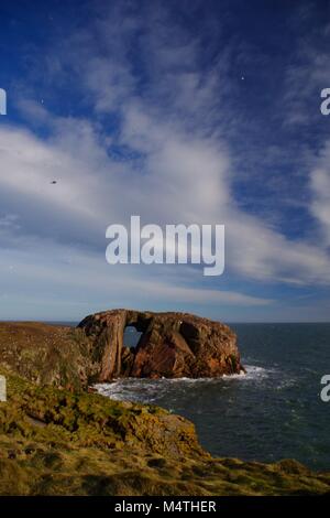 Der Bogen des Dunbuy, natürliche Meer Bogen durch eine rosa Granit Insel entlang der rauen Nordsee Klippen von Buchan, Cruden Bay, Aberdeenshire, Schottland, Großbritannien Stockfoto