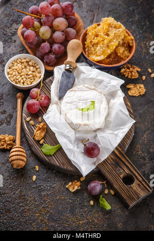 Camembert Käse mit Trauben, Honig in den Waben mit Zedern- und Walnüsse und Mandeln Stockfoto