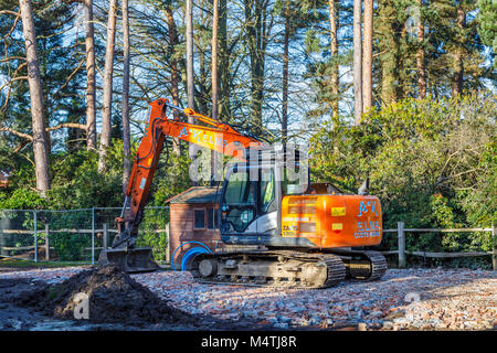 Große orange Mechanische Bagger stehen auf einer Plattform der harte Kern Ziegel Schutt auf ein deaktiviertes Abbruchbaustelle vorbereiten für Wohnungsbau Bauen Stockfoto