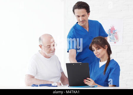 Glücklich senior Patienten und Ärzte im Krankenhaus Stockfoto