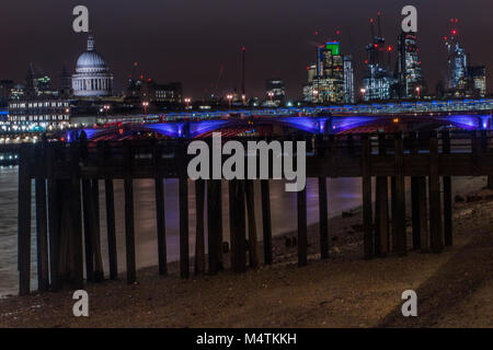 Ebbe und ein Pier am Ufer des South Bank mit St Paul's Kathedrale im Hintergrund ausgesetzt. Stockfoto