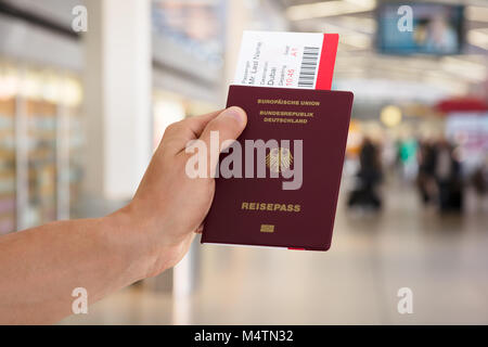 Nahaufnahme einer Hand, die Pass- und Bordkarte am Flughafen Stockfoto