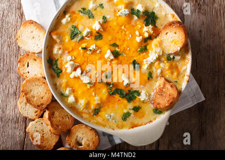 Hausgemachte heiße Buffalo Chicken Dip mit Crostini close up in der auflaufform auf den Tisch. Horizontal oben Ansicht von oben Stockfoto