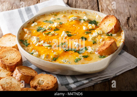 American Food: Hot Chicken Buffalo dip-close-up in einer Auflaufform mit geröstetem Brot auf dem Tisch. Horizontale Stockfoto