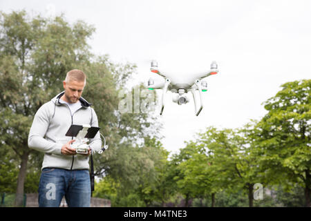 Mann Betrieb der Quadrocopter im Park Stockfoto